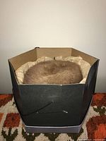 Brown mink fur hat in original box with tissue paper lining.