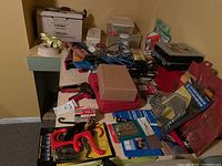 Wide shot of table with assorted tools, hardware, and Kirby carpet shampooer.
