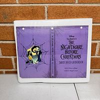 Front cover of the white 3-ring binder showing purple artwork of The Nightmare Before Christmas tarot guidebook with characters and title.