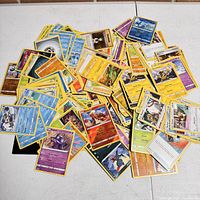 Pile of assorted Pokemon cards showing various characters and energy types