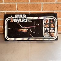 Box cover of the vintage 1977 Star Wars Escape from Death Star game featuring X-wing fighters and character portraits on black background