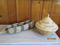 Photo showing both baskets side by side on a tabletop with wood panel background.