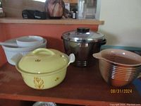Apilco porcelain casserole dish, stainless steel handle sauce pan, and yellow Dru Holland lidded Dutch oven/casserole displaying the cookwares in the lot