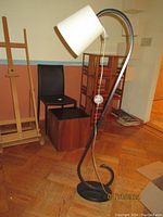 Front and side view of the North Star Designs Eiko arc floor lamp showing curved metal stand, round base, and white fabric shade with pull chain.