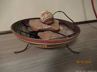 Full view of the tabletop water fountain including painted ceramic bowl, stone slabs, and stoneware jug on top.
