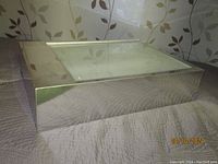 Front and side view of vintage light box showing reflective metallic sides and glass top.