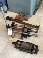 Overview of two screw vises and scissor jack laid on floor