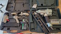 Two pneumatic nailers in open cases showing tools and accessories including nails and oil bottle