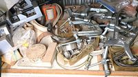 Multiple metal clamps including several C clamps, strap clamps, and miter clamps in disorganized layout