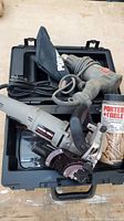 Overview of Porter-Cable plate joiner, heating tool, power cords, dust bag, and a box of wooden biscuits inside a black hard carrying case.