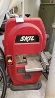 Front view of the red Skil band saw with the Skil logo and power switch visible, showing overall condition and design.