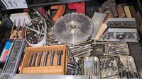Drawer overview showing circular saw blade, wooden Forstner bit rack, metal tins with bits, block plane