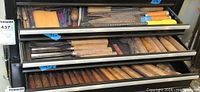 Three drawers open showing rows of chisels in bottom drawer, rasps and files in middle drawer, additional chisels in top drawer