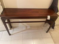 Full view of wooden foyer table showing overall design and finish.