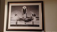 Framed black and white photo of American Airlines twin-engine propeller plane front view with spinning propellers, framed in wood.