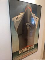 Angled view of framed poster showing the ship's bow and most of the text.