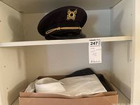 Hat placed on upper shelf with a lot tag visible