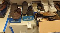 Overview of several pairs of men's shoes including Sperry and Nordstrom shoes in boxes