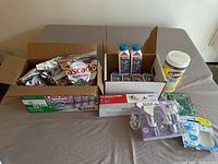 Overview of all cleaning supplies including Cascade pods, Dishwasher Magic bottles, Clorox wipes, lockset, and air fresheners on a table.