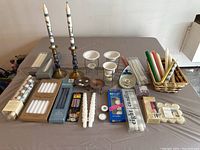 Full display of all candles and holders laid out on table showing variety and amount