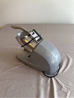 Side view of Horgelu ice crusher showing metal body, handle, and power cord.