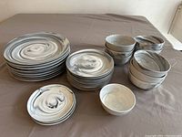 Full view of the 31-piece Lenox Marble Wave dinnerware set with plates and bowls arranged on a table.