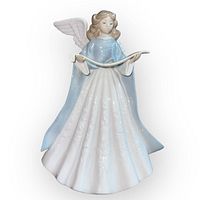 Front view of the Lladro angel figurine featuring the angel holding a scroll, dressed in blue and white porcelain with detailed facial features.