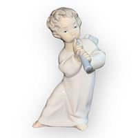 Front angle showing angel playing flute, curly hair, flowing gown, and chip on wing.