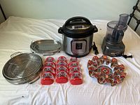 Full view of small appliances and kitchen accessories including Instant Pot, blender, metal steamer tray, taco holders, grill rack, and ceramic taco holder plate.