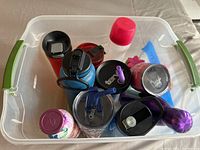 Overview of various water bottles of different sizes and types contained in a plastic bin