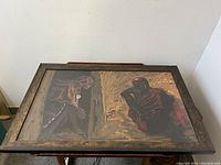 Oil painting signed Richard Kirby showing two figures in a dramatic scene with dark and warm tones in a wood frame.