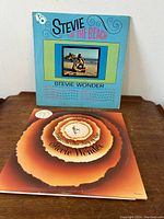 Front cover of 'Stevie at the Beach' album with blue background, photo of Stevie Wonder at the beach, and album details.