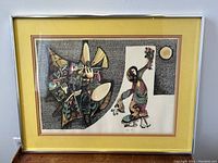 Framed lithograph showing abstract figures and patterns in the artwork, with detailed color and design, under glass with yellow matting