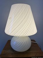 Lamp unlit, front view showing white swirled glass base and shade.