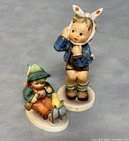 Two Goebel Hummel figurines showing front view on grey surface