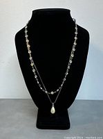 Front view of both vintage 925 silver necklaces displayed on black bust.