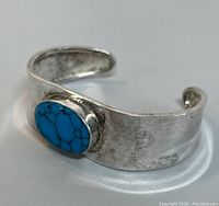 Front and side view of the sterling silver cuff bracelet with oval turquoise stone, showing wear and detailed texture on silver band.