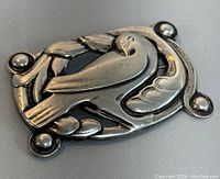 Front angled view of the vintage CORO sterling silver dove brooch showing the dove design and textured frame.