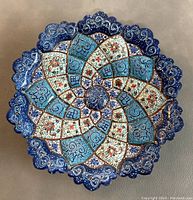 Top view of the circular Persian enamel Mina plate showing detailed floral and geometric enamel design with scalloped edges