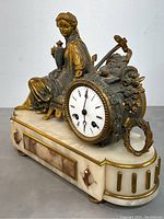 Side angle showing the bronze seated lady figure holding an urn, the clock face, and alabaster base with marble accents.