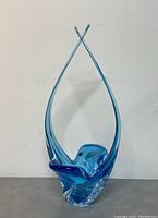 Front view of blue hand blown art glass centerpiece showing shape and color.