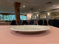 White circular dinner plate resting on table in a restaurant setting.