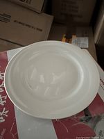 Top view of a single white circular plate showing its smooth surface and simple design.