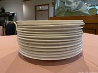 Stacked view of multiple off-white circular plates showing thickness and uniformity.