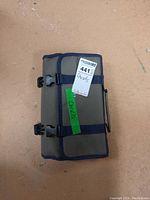 Grey canvas roll-up pouch closed with blue binding, two black plastic quick-release buckles and carry handle