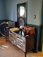 Front-left view of dresser with mirror and items on top