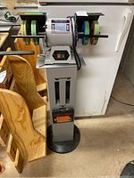 Full view of grinder mounted on metal pedestal stand