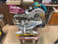 Overall view of saw on mounting table with base, sliding rails and motor visible