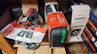 View showing Porter-Cable router base, boxed Makita sander model B05011, MicroFurnace heater in box, and other boxed items.