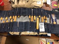 Overview of two tool rolls: beige canvas and blue denim pouch with wood turning tools